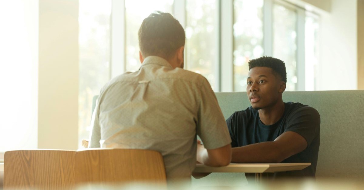 Two men talking across a table