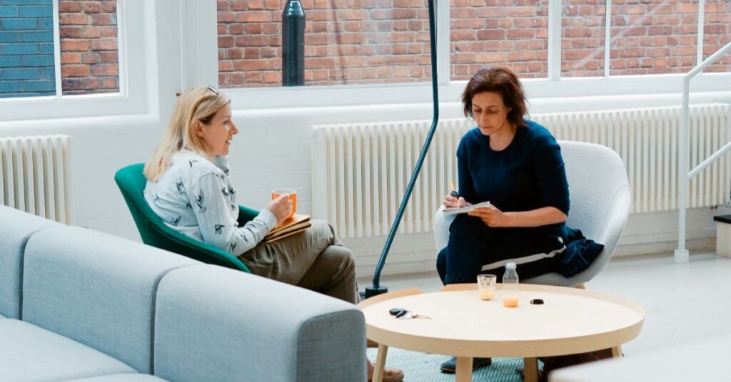 Therapy session with two women sat across from each other.
