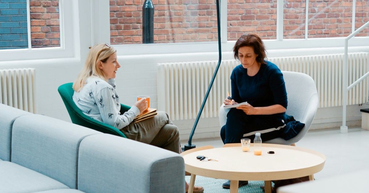 Therapy session with two women sat across from each other.